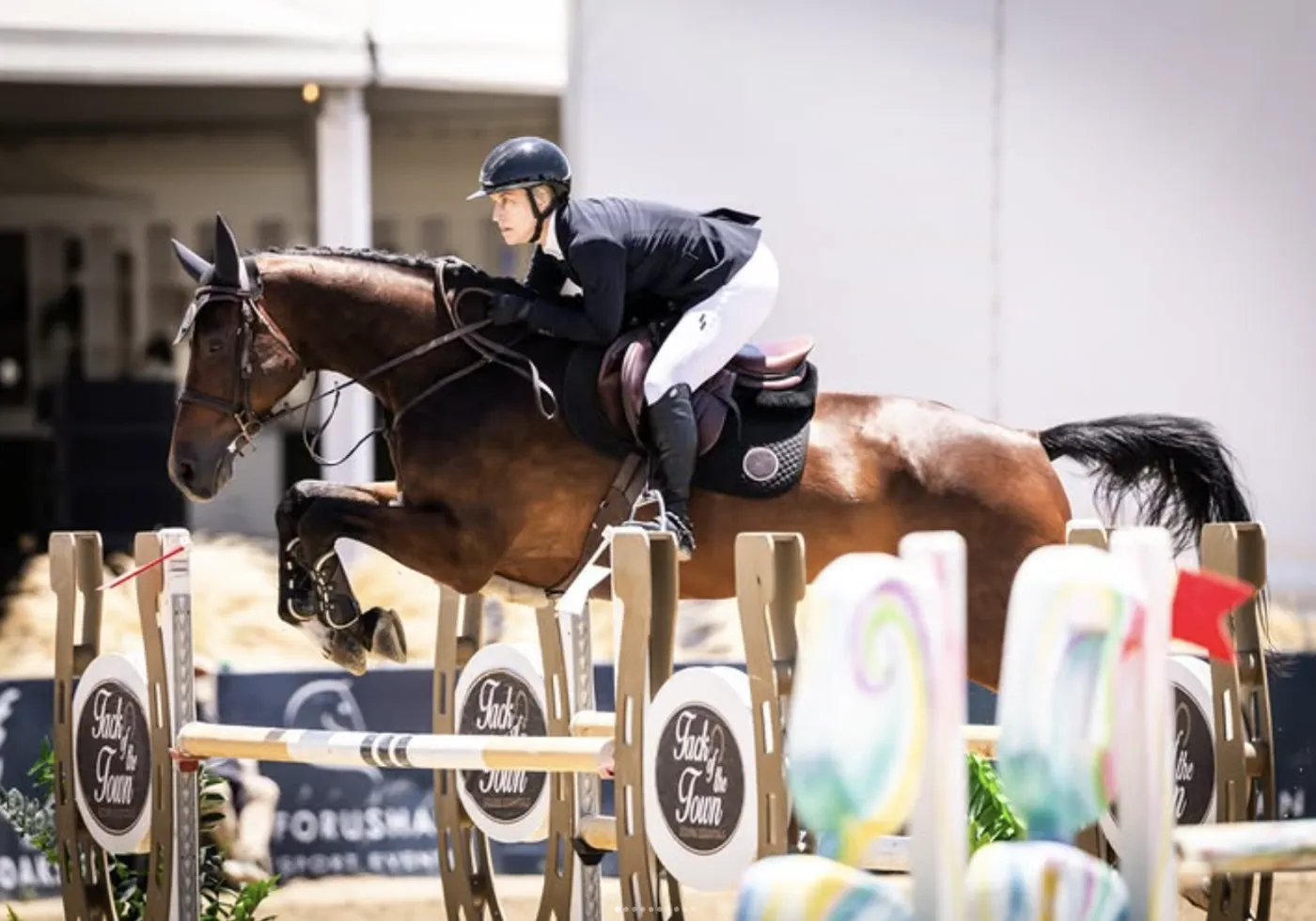 Jumper clearing an oxer at competition